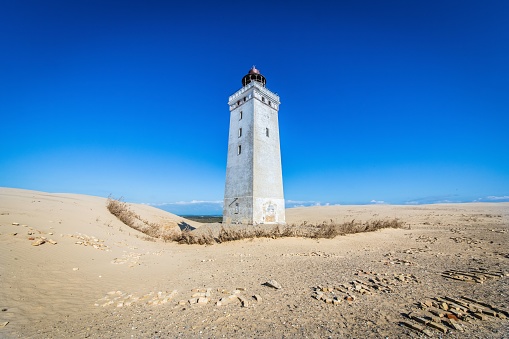 The iconic lighthouse Rubjerg Knude Fyr in the dunes of northern Denmark on a summer day