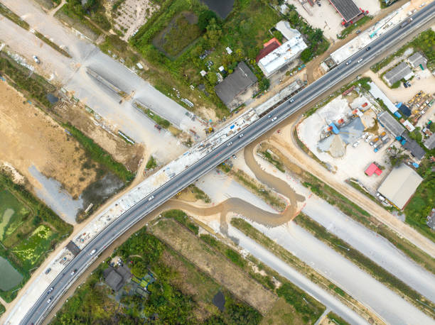 istock Aerial image of a road construction machine During the asphalting process, an asphalt paver, roller, and truck are seen on the road repair site. Top-down aerial picture of tram track repair. 1443459089