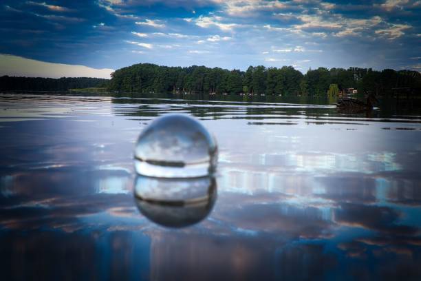 istock Crystal ball in the lake surrounded with trees reflecting its surroundings 1443459131