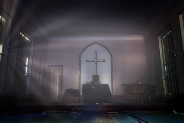 istock Interior of an abandoned room for worship with lights hitting from broken windows 1443459870