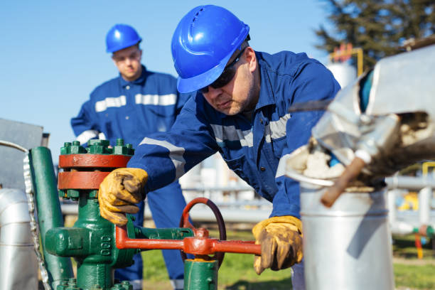 istock Oil worker turning valve on oil rig 1443463037