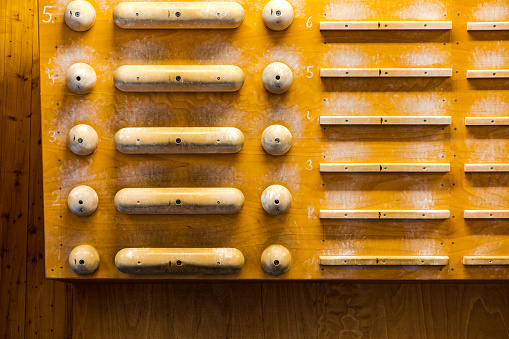 Shot of wooden finger board at a climbing gym. Finger board for practicing at indoor climbing center.