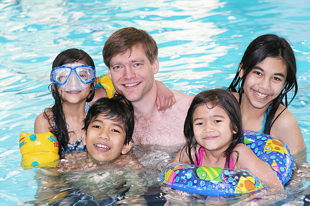 istock Father swimming with his four children 144346501