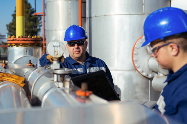 istock Two Factory worker in a hard hat on Heavy equipment and pipeline 1443465743