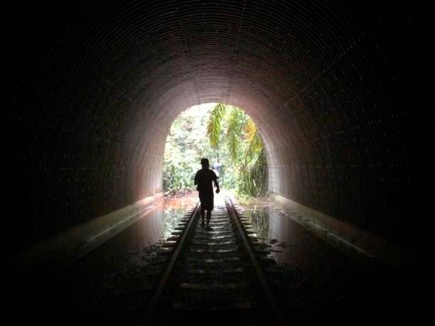 istock Silhouette man on a tunnel with a railway track 1443465755
