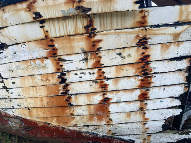 Close-up of the wooden plank and the spaces in between, the paint is peeling off, with rusty nails in the wood. On the Breton coast of northwestern France, Finistere department