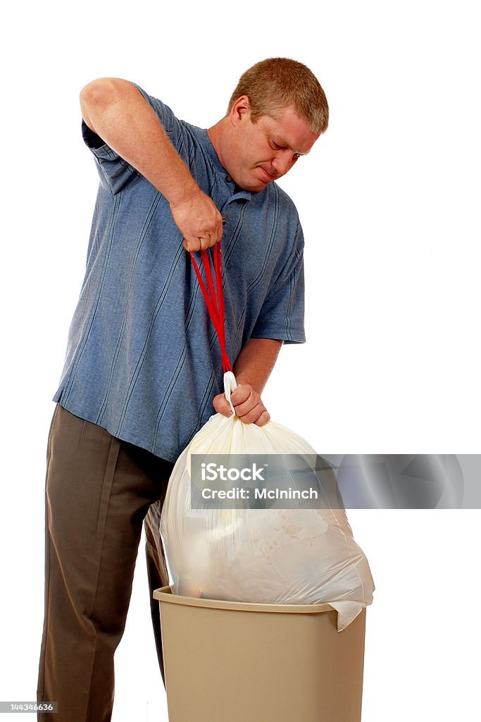 Ugh! Man pulling an overstuffed bag of trash from the trashcan. Isolated on white. Garbage Stock Photo