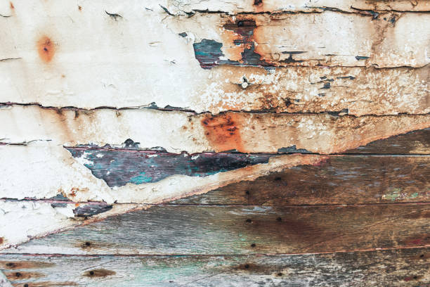 Close-up of the wooden plank and the spaces in between, the paint is peeling off heavily. On the Breton coast of northwestern France, Finistere department