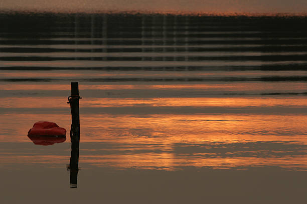 Life vest and Mooring Pole in Golden sunset stock photo