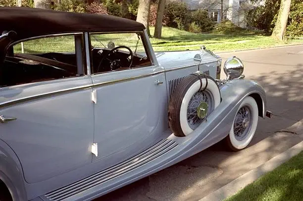 Photo of vintage Rolls Royce automobile parked on a neighborhood street.