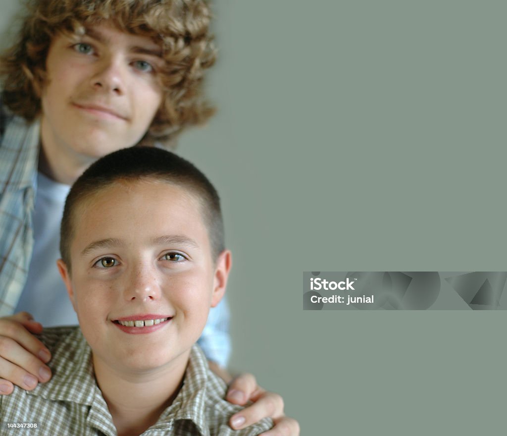 Two brothers Older teen supporting his younger kid brother Advice Stock Photo