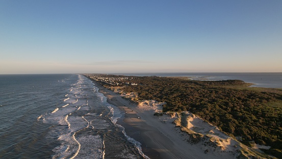 An aerial view of sea waves crashing into the sandy beach of Outer Banks island North Carolina