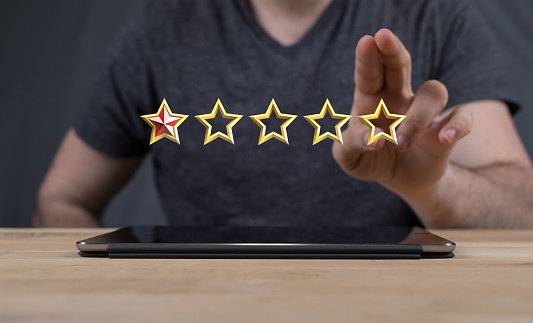 A 3D rendered five stars icon hovering in mans hand