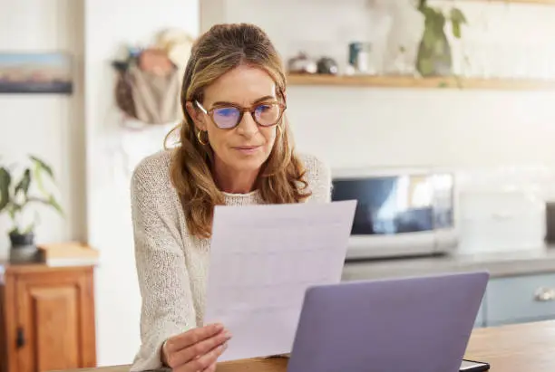 Budget, finance and retirement woman with laptop and paperwork for pension savings, bills or income investment on digital bank app. Elderly person with mortgage, financial document or tax management