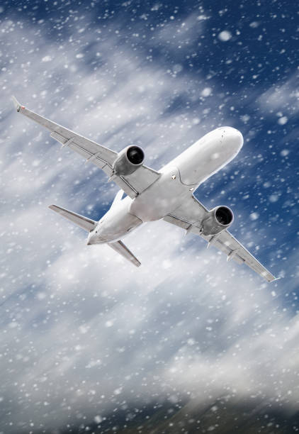istock white passenger plane hurtles through rushing snow against a backdrop of mountains with white clouds.  Landscape with airplane, mountains and sky with white clouds in winter. 1443477251
