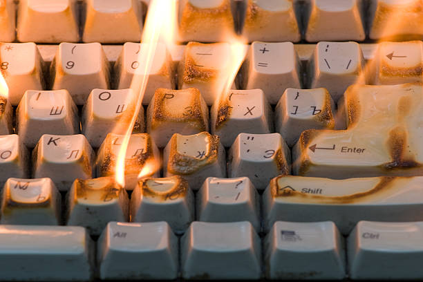The burning keyboard Fire on a desktop. The poor-quality computer blazes. inferno photos stock pictures, royalty-free photos & images