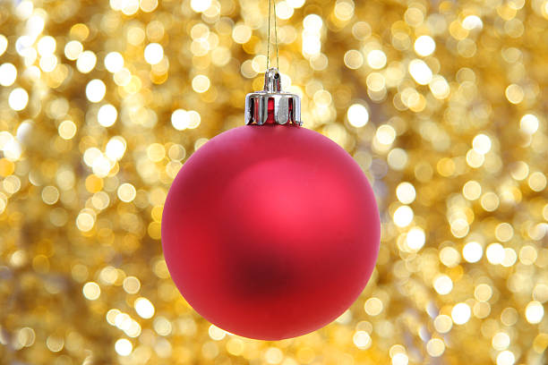 Red christmas ball against sparkling golden background stock photo