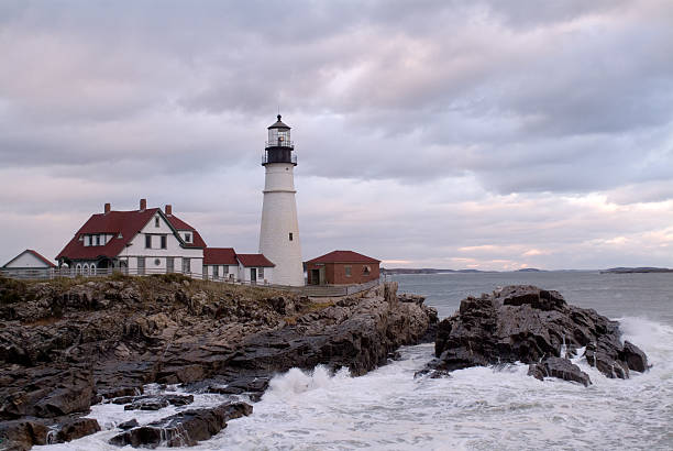 Maine lighthouse at dusk Old Maine ligthouse just after sunset with a beautiful cloudy sky and some crashing waves. majkav stock pictures, royalty-free photos & images