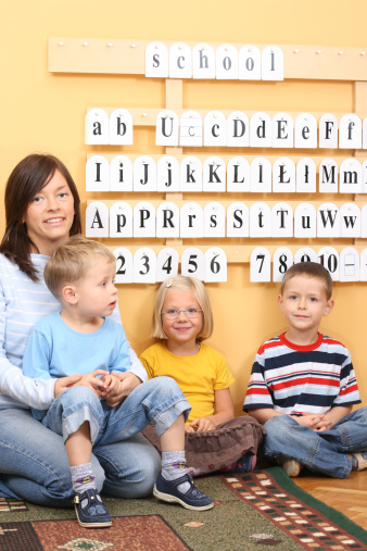 teacher and three preschoolers during lesson