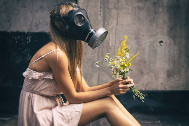 Young woman in Gas mask with flowers stock photo