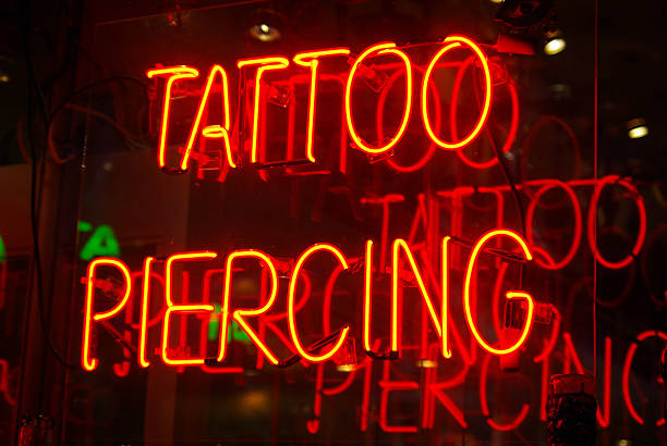 Tattoo parlor sign Neon sign in the window of a tattoo parlor in New York City Pierced stock pictures, royalty-free photos & images