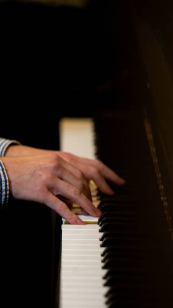 istock Vertical shot of hands playing a piano 1443481344