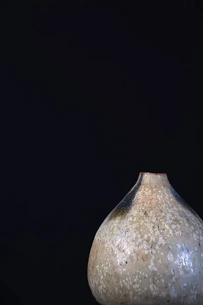 An earthen pot with the concept of leading into the open space visually isolated on a black background.