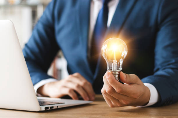 istock Innovation through ideas and inspiration ideas. Human hand holding light bulb to illuminate, idea of creativity and inspiration concept of sustainable business development. 1443482488