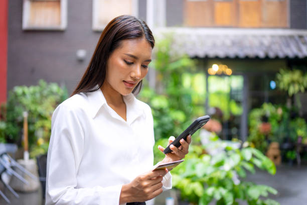 istock Young woman is using a digital device for electronic banking at public place. 1443482782