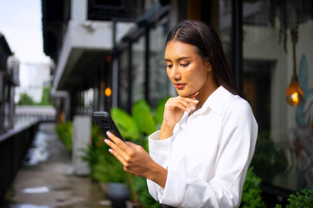 istock Young woman is using a digital device for electronic banking at public place. 1443482814