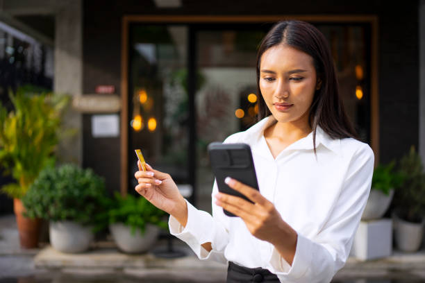 istock Young woman is using a digital device for electronic banking at public place. 1443482854