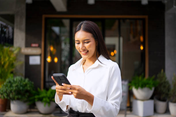 Young woman is using a digital device for electronic banking at public place.