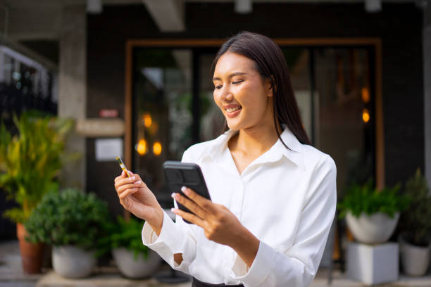 istock Young woman is using a digital device for electronic banking at public place. 1443482875