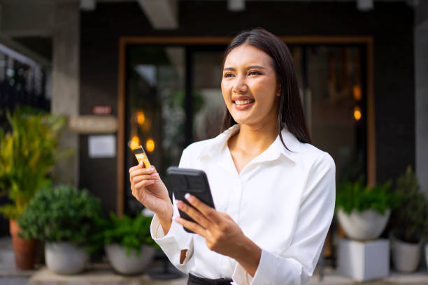 istock Young woman is using a digital device for electronic banking at public place. 1443482881