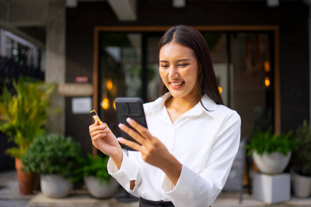 istock Young woman is using a digital device for electronic banking at public place. 1443482884