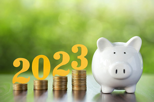 Text of 2023 on top of coins stacks with a piggy bank. 2023 New year saving money and financial planning concept. Business financial planning ideas for goals in 2023.Budget 2023. and banking.