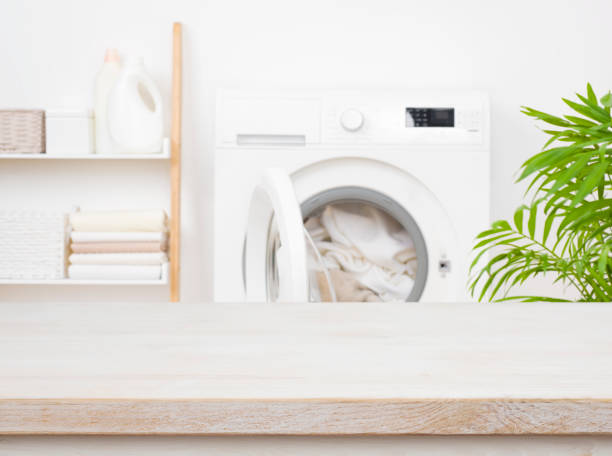 istock Empty wooden table in blurred laundry room with washing machine 1443489381