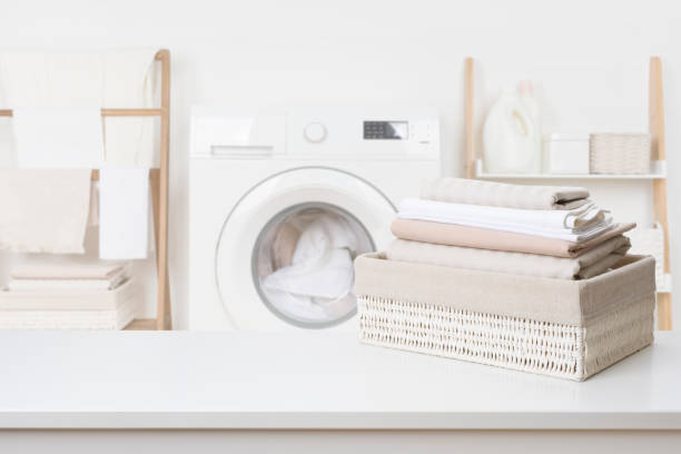 istock Clean laundry in basket on white table over blur bathroom 1443489382