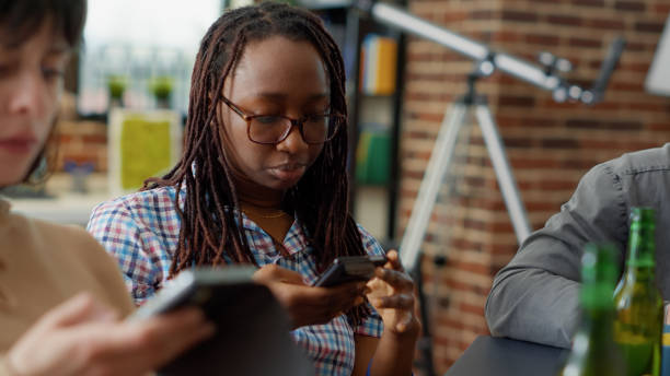 istock Multiethnic group of friends sitting together and using smartphone 1443490980