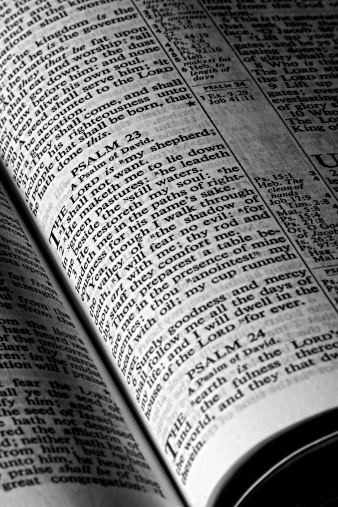 Close-up black and white photo of an opened Bible. The 23rd Psalm is at the center.