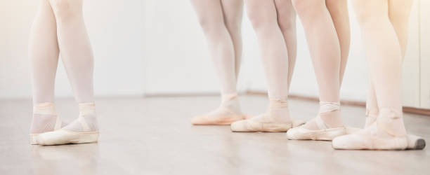 istock Ballet, leader and dancer group feet in dance studio training in artist academy with white wall and floor. Women team, class or students dancing on pointe shoes for school performance with lens flare 1443493453