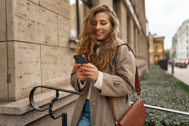istock Young woman using mobile device standing in the city 1443493656