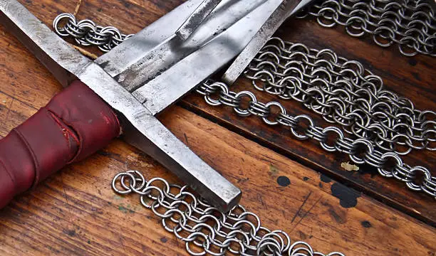 Sword laying on a table, a circuit and a chain armour.