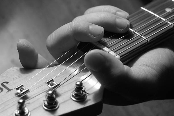 istock Hand holding guitar black and white 144349474