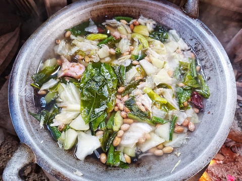 Traditional cooking with a stove and firewood, a full wok of sayur asam is a popular Indonesian vegetable in tamarind soup. Common ingredients are peanuts, young jackfruit, long bean and cabbage