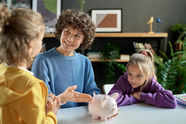 Mother teaching her children to save money stock photo