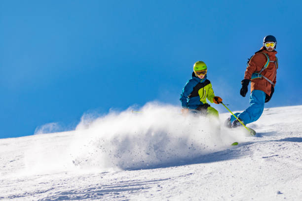istock Father and son skiing and snowboarding in mountains 1443495751