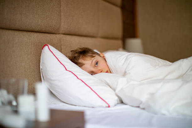 istock School age boy laying in bed with a flu 1443495953