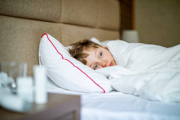 istock School age boy laying in bed with a flu 1443495960