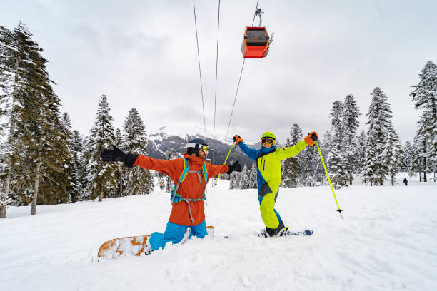 istock Father and son skiing and snowboarding in mountains together 1443496104